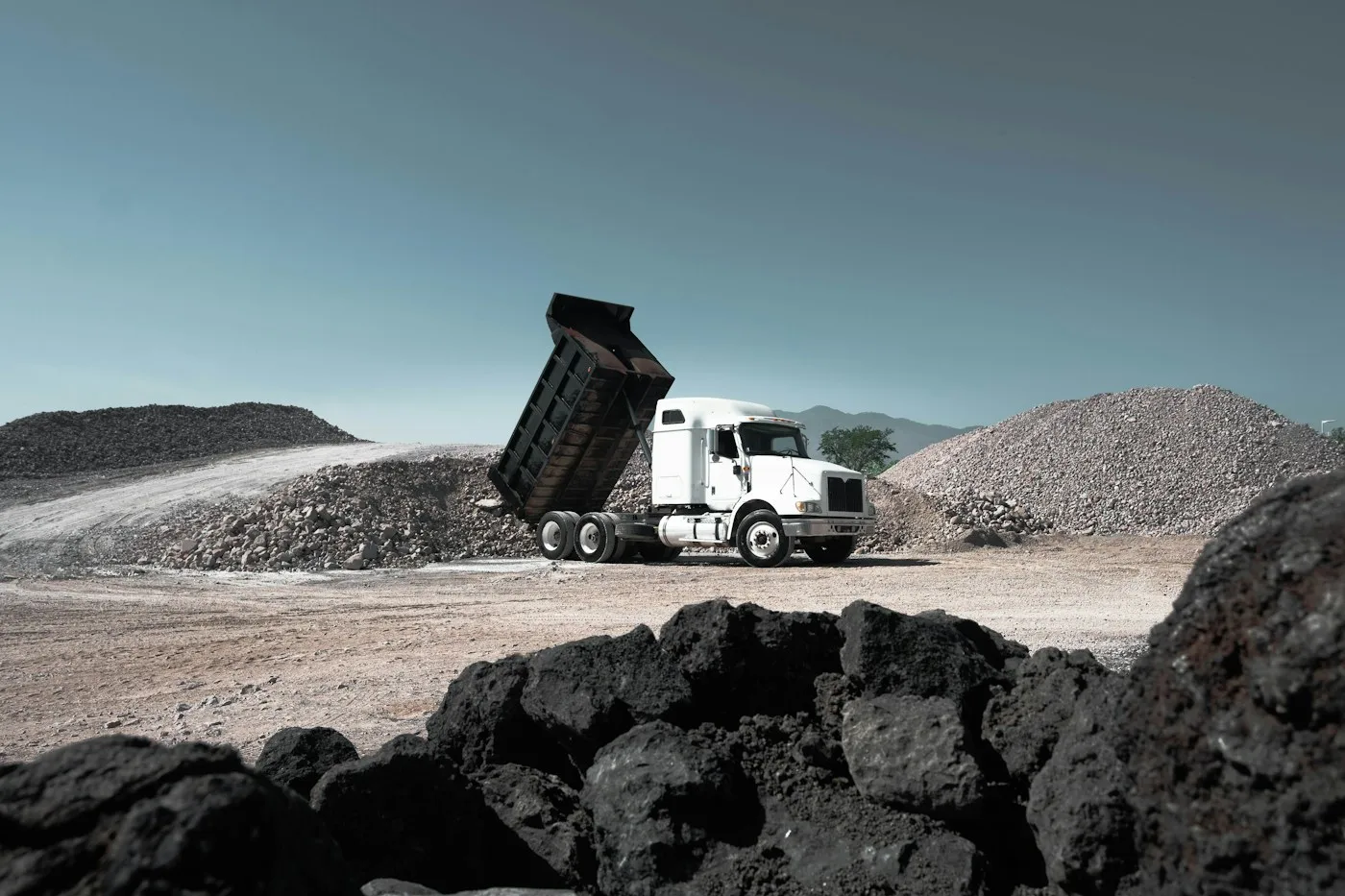 Dump truck unloading aggregate at a materials site